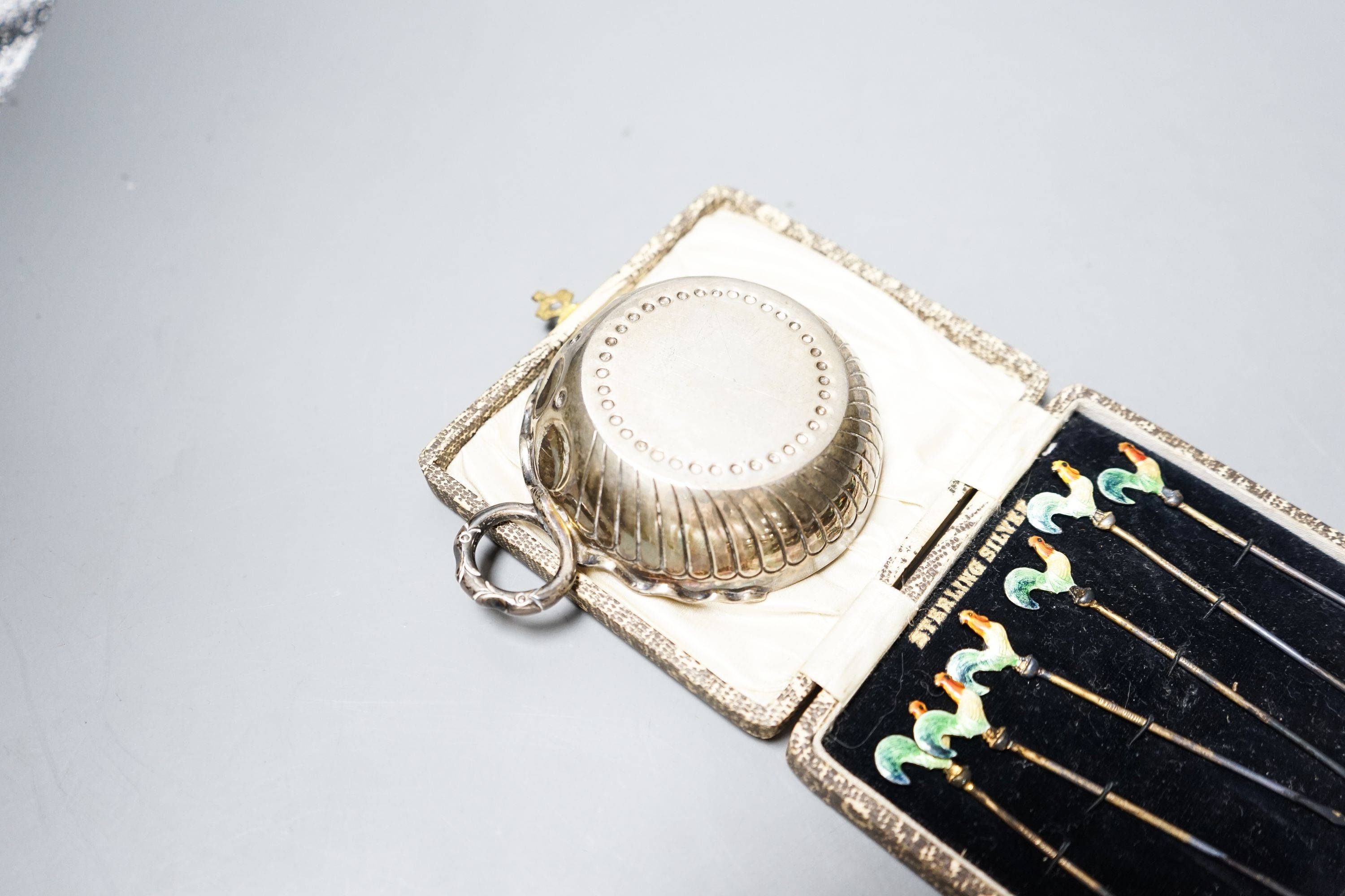 A 1930's silver taste vin and a cased set of six sterling and enamel cocktail sticks.